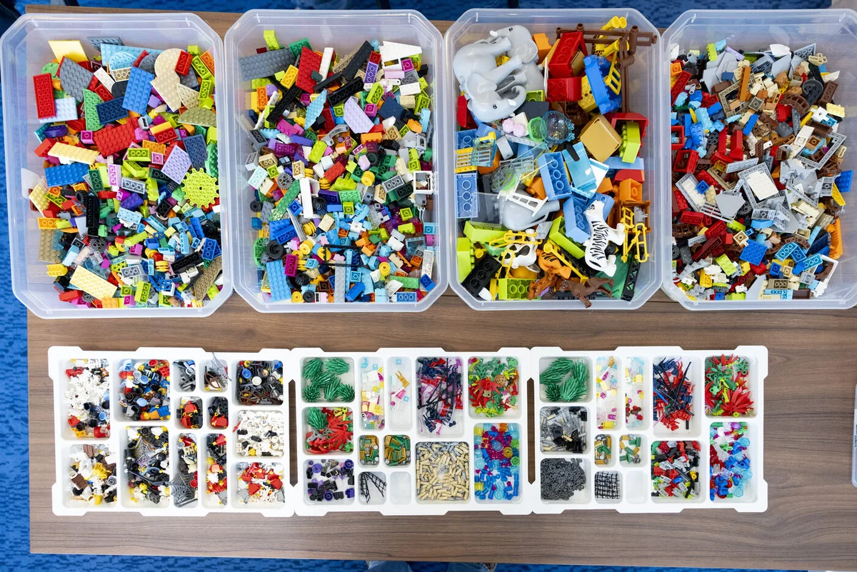 Top-down view of LEGO Serious Play kit — sorted by category in clear trays
